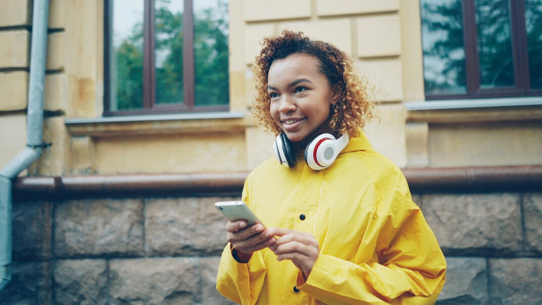 Smiling woman with headphones studying online on a laptop
